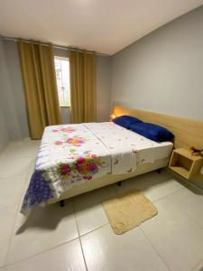 1 dormitorio con 1 cama con edredón de flores en Apartamento de 01 quarto, novíssimo, em Ipiabas., en Barra do Piraí