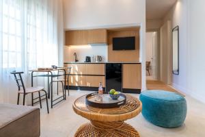 a living room with a couch and a table and a kitchen at Naillac Elite Suites in Rhodes Town