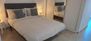 a bedroom with a large white bed and a mirror at Large Studio with view-Hosted by Sweetstay in Gibraltar