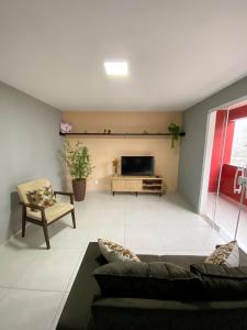 sala de estar con sofá y TV en Apartamento de 01 quarto, novíssimo, em Ipiabas., en Barra do Piraí