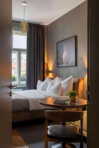 a hotel room with a bed and a table and a window at The Viaduct - Suites & More in Prague