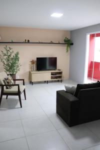sala de estar con TV de pantalla plana en la pared en Apartamento de 01 quarto, novíssimo, em Ipiabas., en Barra do Piraí