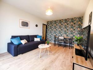 - un salon avec un canapé bleu et une table dans l'établissement LA BELLE BALADE - Parking - Wifi - Balcon - Belle vue !, à Annecy