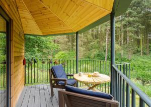 een veranda met een tafel en stoelen op een terras bij Riverside Cabins in Shrewsbury