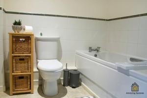 a bathroom with a toilet and a bath tub at Homely 2 Bed Flat Sleeps 4 with Parking and Wifi by Amazing Spaces Relocations Ltd in Warrington