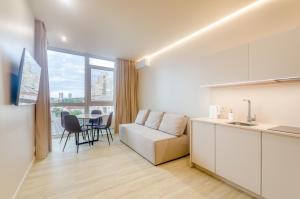 a kitchen and living room with a couch and a table at 638 Cozy apartment in the residential complex "French Quarter" in Kyiv