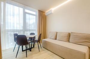 een slaapkamer met een bed en een tafel en stoelen bij 638 Cozy apartment in the residential complex "French Quarter" in Kiev