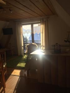 Una sala de estar con una ventana y una mesa. en Apartamenty i pokoje rodzinne, en Czarna Góra