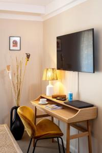 a room with a desk with a laptop and a chair at Hôtel Escaletto in Aix-en-Provence
