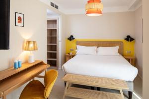 a bedroom with a bed and a desk and a chair at Hôtel Escaletto in Aix-en-Provence