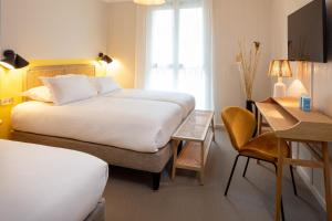a hotel room with two beds and a table and a desk at Hôtel Escaletto in Aix-en-Provence