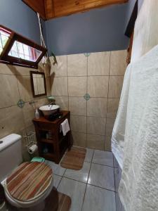 y baño con aseo y lavamanos. en Cabaña El Ceibo en Puerto Iguazú