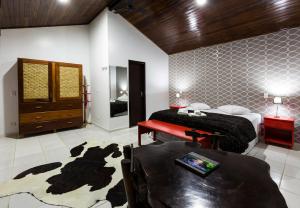 a bedroom with two beds and a table in it at Pousada Camury in Garuva