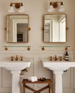 two sinks in a bathroom with two mirrors at Inness in Accord