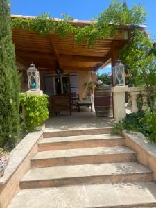 a patio with a wooden pergola and stairs at Maison de vacances dans le verdon in Saint-Julien +22 photos