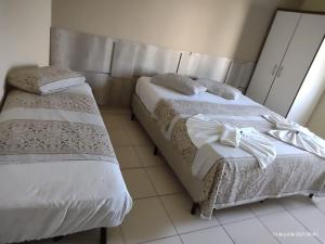 two beds sitting next to each other in a room at Hotel Pousada Miami in Itanhaém