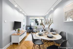 a living room with a table and chairs and a tv at Kameralny apartament nad morzem Possession pl in Gdańsk