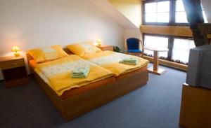 um quarto com uma cama grande com lençóis amarelos em Pension Smetanuv statek em Hradec Králové