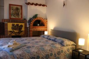 ラポラーノ・テルメにあるAppartamento Boscodisottoのベッドルーム(ベッド1台、レンガ造りの暖炉付)