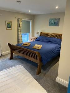 um quarto com uma cama grande com lençóis azuis e uma janela em Flat 2, 22 the square centre of Dalston village em Dalston