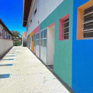 a colorful building with doors on the side of it at Chalés Sununga Flats a 1 minuto da praia in Ubatuba +10 photos