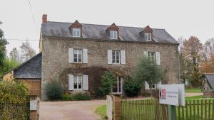 uma grande casa de tijolos com uma placa em frente em Domaine de la Basse Orme em Les Iffs