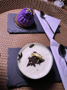un pastel púrpura en una mesa con un plato y una cuchara en Starwatching Private Camp en Ḩawīyah