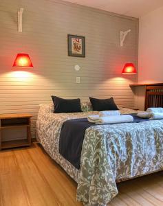 1 dormitorio con 1 cama grande y 2 lámparas en Hostería Suiza - Ex Casita Suiza en San Carlos de Bariloche