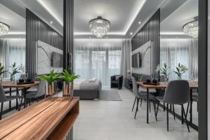 jadalnia ze stołami i krzesłami oraz sypialnia w obiekcie Apartament Tokyo HANZA POOL w Szczecinie