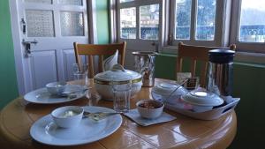 a wooden table with plates and dishes on it at Prairie Lodge in Shimla