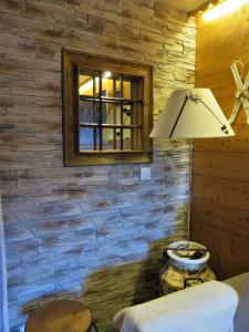 lámpara en una habitación con pared de piedra en Pensée Des Alpes 2 Etoiles Ski and Spa en Brides-les-Bains
