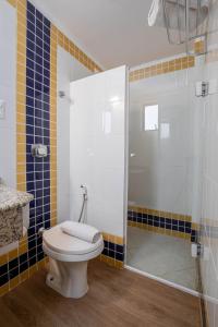 een badkamer met een toilet en een glazen douche bij Hotel Italia in Balneário Camboriú