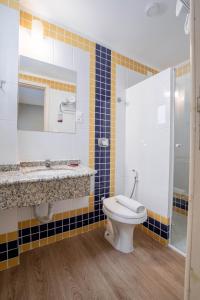 a bathroom with a toilet and a sink and a shower at Hotel Italia in Balneário Camboriú