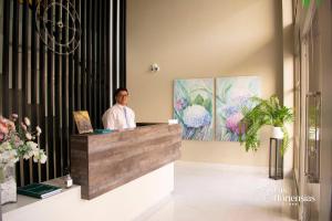 a man sitting at a reception desk in a room with flowers at Las Hortensias Hotel in Monteros