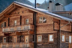 a log cabin with balconies on the side of it at Appartements Höllhaus in Innervillgraten