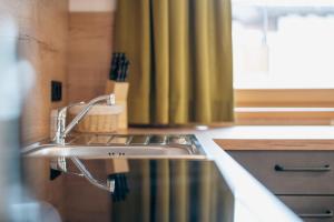 a kitchen with a stainless steel sink and a window at Appartements Höllhaus in Innervillgraten