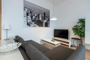 uma sala de estar com um sofá e uma televisão de ecrã plano em Penthouse with a View of Lodz & Free Parking em Lódź