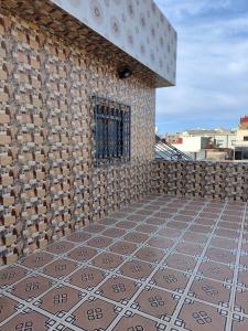 a brick wall with a tile floor next to a window at STUDIO NEUF PROPRETE ET HYGIENE IRREPROCHABLE Proche des bus CTM - 4 em étage face terrasse in Tangier