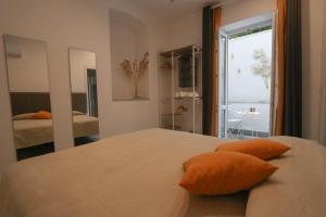 1 dormitorio con 1 cama con almohadas de color naranja en Casanica-Taormina, en Taormina