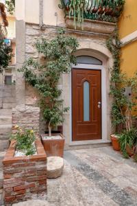 タオルミーナにあるCasanica-Taorminaの木の前の建物の扉
