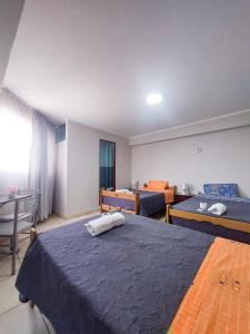 Habitación de hotel con 2 camas y mesa en Residencia Benavides, en San Vicente de Cañete