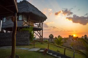 a house with the sunset in the background at Pousada Theodora in Macapá