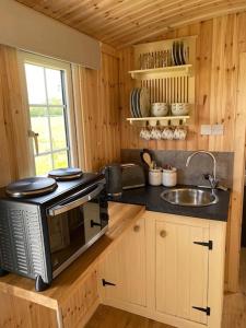 cocina con microondas y fregadero en Shepherd Hut, en Warwick