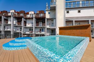 a swimming pool in front of a building at Apartamenty Jeanette in Rowy
