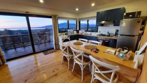 a kitchen with a table and chairs and a large window at Moon River Puerto Varas in Puerto Varas