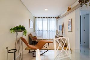 - un salon avec une table en verre et une chaise dans l'établissement Apartamento com a cara de Maceió, à Maceió