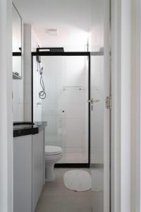 La salle de bains est pourvue de toilettes et d'une douche en verre. dans l'établissement Apartamento com a cara de Maceió, à Maceió