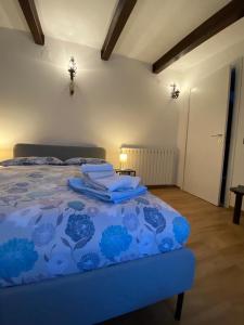 ラポラーノ・テルメにあるAppartamento Boscodisottoのベッドルーム1室(青い掛け布団付きのベッド1台付)