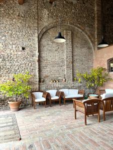 een groep stoelen en tafels voor een stenen muur bij Corte Mondina in Gazoldo degli Ippoliti