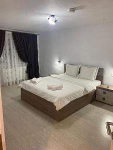 een slaapkamer met een groot bed met twee handdoeken erop bij Double D Apartments in Lupeni +10 foto's